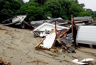 土砂により家屋や車の一部が埋もれている杷木松末地区